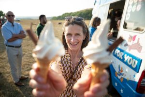 Wedding guest smiling while holding two Whippy cones with Flakes in front of the van.